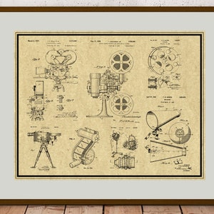 Peut inclure: Un dessin de brevet vintage en noir et blanc d'une cam&eacute;ra et d'un projecteur de cin&eacute;ma. Le dessin est sur un fond beige et comprend du texte qui se lit "March 3, 1917" et "Aug. 15, 1916".