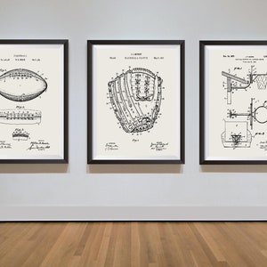 May include: Three black framed prints of vintage sports equipment patent drawings. The left print shows a football, the middle print shows a baseball glove, and the right print shows a basketball hoop.
