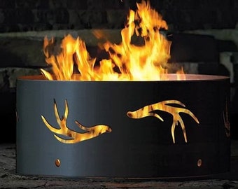 Könnte beinhalten: Ein schwarzer Metall-Feuerplatz mit einem ausgeschnittenen Design von Geweih. Der Feuerplatz ist mit Flammen gefüllt.