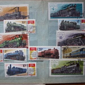 May include: A collection of vintage Soviet postage stamps featuring various steam locomotives. The stamps are arranged in a grid pattern on a light blue background. The stamps feature different locomotive designs and have various denominations, including 2, 4, 6, 10, 15, 20, and 30 kopecks. The stamps are in good condition and have a classic look.