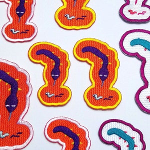 May include: Set of ten embroidered iron-on patches featuring colourful cartoon worms with different coloured bodies and legs. The worms are in a variety of poses, including standing, sitting, and crawling.