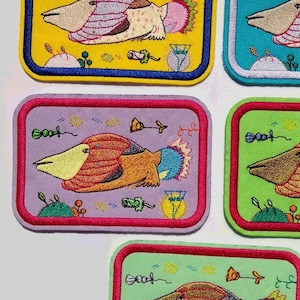 Pode incluir: Cinco patches bordados para passar a ferro que representam peixes coloridos com detalhes caprichosos. Os patches estão sobre um fundo branco e estão prontos para serem passados a ferro em tecido.