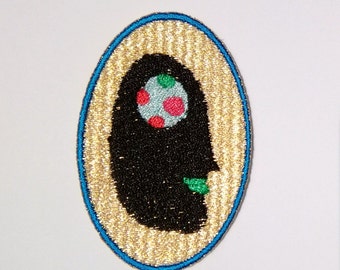 floating face embroidery iron patch home made gold flashy gloss black weird creepy person appliqué