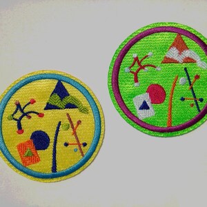 K&ouml;nnte beinhalten: Zwei gestickte Aufn&auml;her mit abstrakten geometrischen Mustern. Der erste Aufn&auml;her ist gelb mit einem blauen, gr&uuml;nen und roten Muster. Der zweite Aufn&auml;her ist gr&uuml;n mit einem roten, orangen und wei&szlig;en Muster.