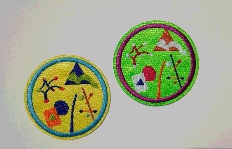 K&ouml;nnte beinhalten: Zwei gestickte Aufn&auml;her mit geometrischen Formen und abstrakten Designs. Ein Aufn&auml;her ist gelb mit einem blauen Rand und der andere ist gr&uuml;n mit einem violetten Rand.