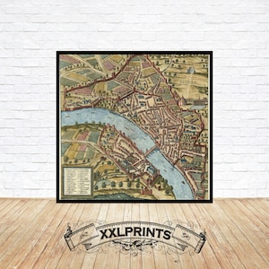 Peut inclure: Une carte ancienne de la ville de Bâle, en Suisse, avec une rivière qui la traverse. La carte est dans un cadre noir et a un aspect vintage.