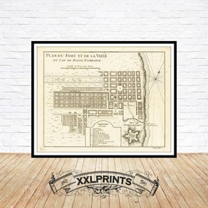 May include: A vintage map of the Fort and City of Cape of Good Hope, printed in black and white. The map shows the layout of the fort and city, with streets, buildings, and other features labelled in French.
