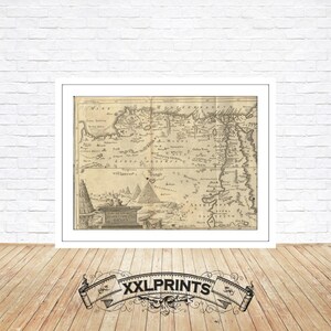 Op de afbeelding: Een vintage kaart van Egypte, gedrukt in zwart-wit, met een decoratieve rand. De kaart toont de Nijl, de piramides en andere bezienswaardigheden. De kaart is getiteld "A New Map of Egypt".