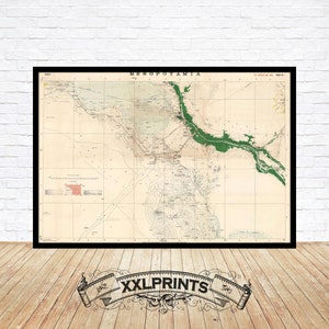 Op de afbeelding: Vintage kaart van Mesopotamië, gedrukt op verouderd papier met een groene omtrek van de Tigris en Eufraat. De kaart is zwart ingelijst en heeft de titel "Mesopotamia" bovenaan.