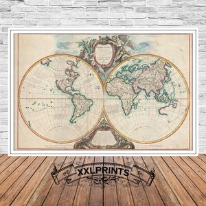 May include: A framed vintage world map print. The map is divided into two hemispheres, showcasing continents and oceans in muted colors. The print is set against a white brick wall and a wooden floor. The text "XXLPRINTS" is at the bottom.