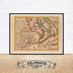 May include: Framed antique map print with a black frame. The map features detailed geographical elements in shades of beige, brown, green, and red. The print is displayed on a white brick wall above a wooden floor. The text "XXLPRINTS" is at the bottom.
