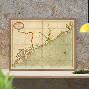 May include: An antique map of the coast of South Carolina and Georgia, framed in a brown wood frame. The map is printed on aged paper with a grid pattern and shows the coastline, rivers, and towns.