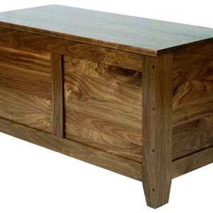 Puede incluir: Un cofre de almacenamiento de madera con un acabado marr&oacute;n oscuro. El cofre tiene una tapa con bisagras y dos paneles en la parte delantera.