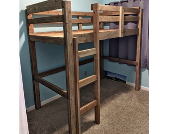 May include: A wooden loft bed with a ladder on the side. The bed is made of natural wood with a rustic finish. The bed is in a room with light blue walls and a carpeted floor.