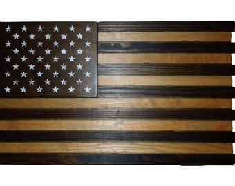 May include: A wooden American flag with black and brown stained wood. The stars are white and the stripes are red, white, and blue.