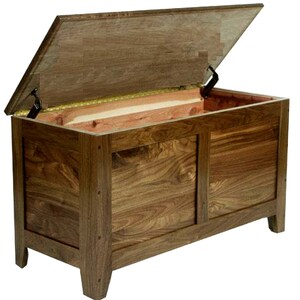 Puede incluir: Un cofre de almacenamiento de madera con una tapa con bisagras y dos puertas. El cofre est&aacute; hecho de madera marr&oacute;n oscura con veta de madera natural. La tapa est&aacute; abierta y el interior es visible. El cofre tiene cuatro patas y est&aacute; sentado sobre un fondo blanco.