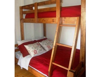 May include: A wooden bunk bed with a red mattress on the top bunk and a red comforter on the bottom bunk. The bed has a ladder on the side.