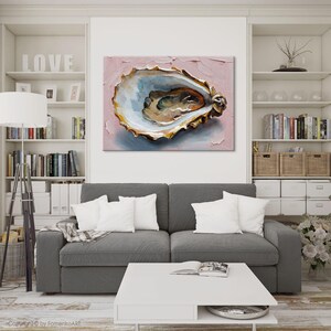May include: An oyster painting with a textured, pink background. The oyster shell is detailed with gold, blue, and brown tones. The artwork is displayed above a gray sofa with white pillows in a living room setting.