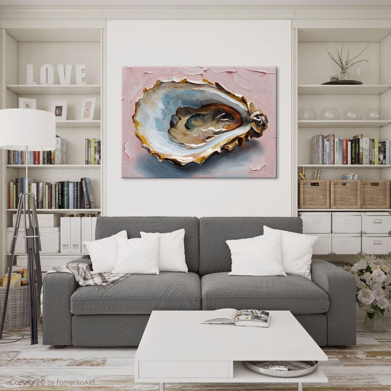 May include: An oyster painting with a textured, pink background. The oyster shell is detailed with gold, blue, and brown tones. The artwork is displayed above a gray sofa with white pillows in a living room setting.
