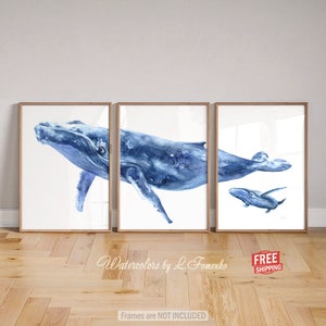 May include: A set of three watercolor paintings featuring a blue whale and a baby whale. The paintings are framed and ready to hang. "Watercolors by L. Fomenko" is written at the bottom of the image.