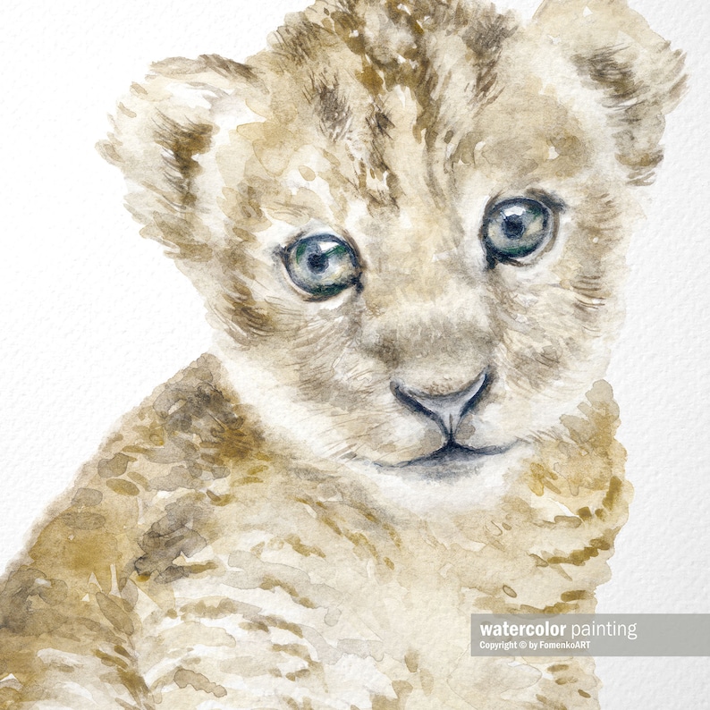 May include: A watercolor painting of a light brown lion cub with blue eyes. The cub is looking directly at the viewer. The painting is on a white background.