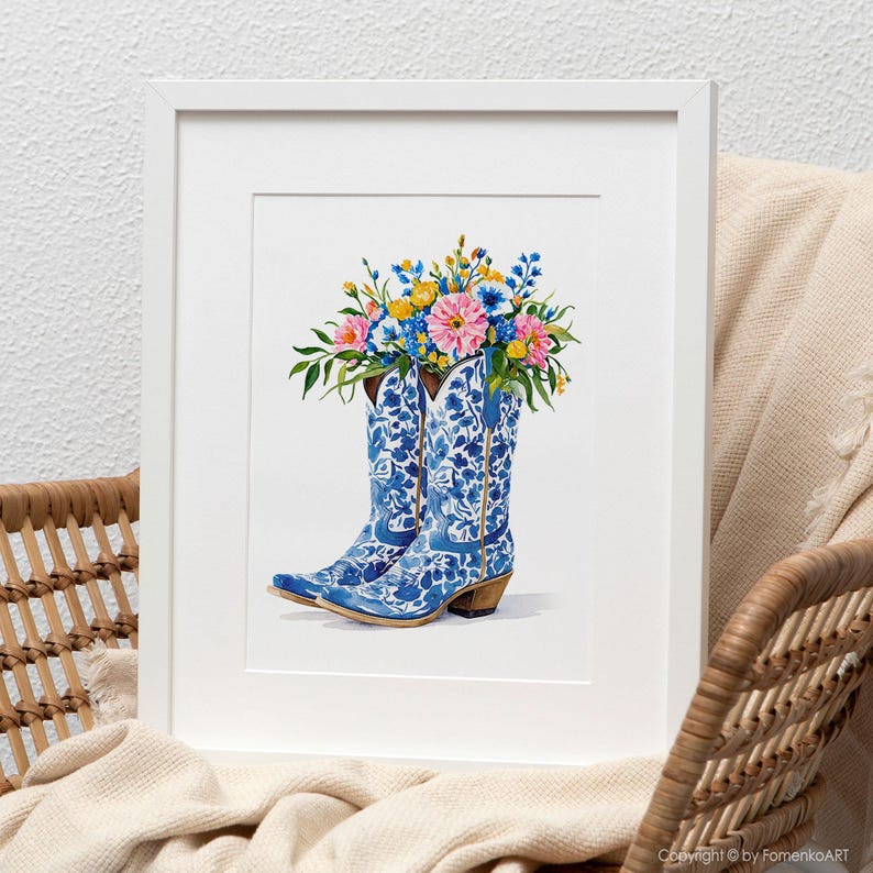 May include: A framed watercolor print featuring a pair of blue and white floral cowboy boots filled with a vibrant bouquet of pink, yellow, and blue flowers. The artwork is set against a neutral background, creating a charming country-chic aesthetic.