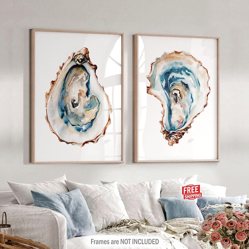Puede incluir: Dos impresiones enmarcadas en acuarela de conchas de ostras. La obra de arte presenta representaciones detalladas de conchas de ostras con tonos de azul, marr&oacute;n y blanco. Los marcos son de color madera clara. El texto "Frames are NOT INCLUDED" est&aacute; en la parte inferior.