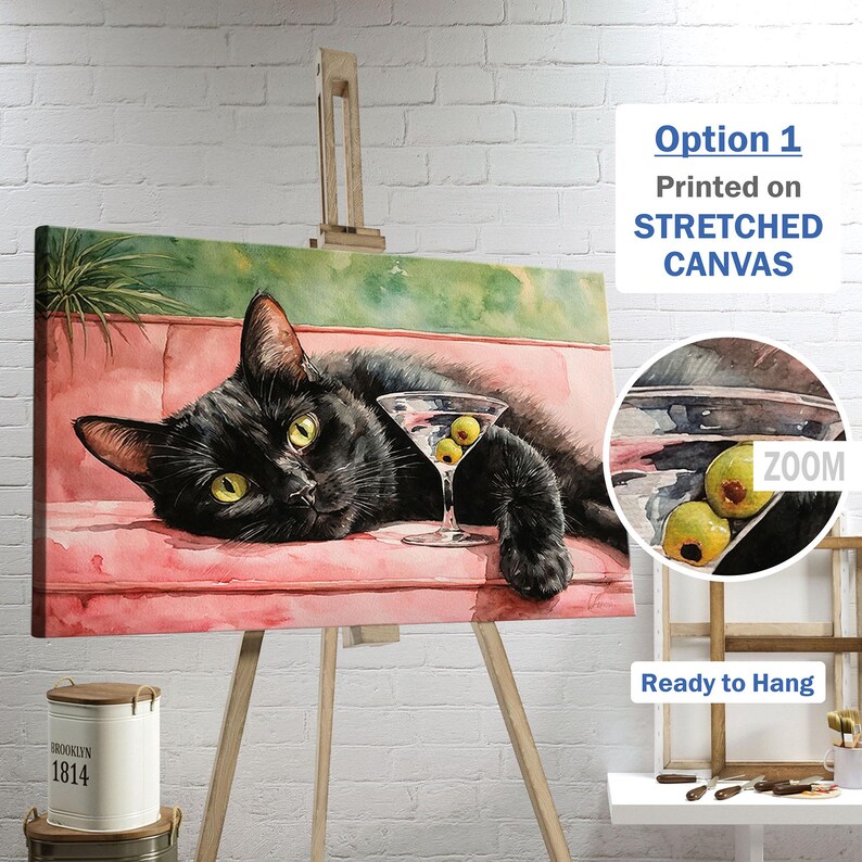 May include: A canvas print depicting a black cat relaxing on a pink sofa, with a martini glass containing olives. The artwork is displayed on an easel. Text on the print reads "Option 1 Printed on STRETCHED CANVAS" and "Ready to Hang".
