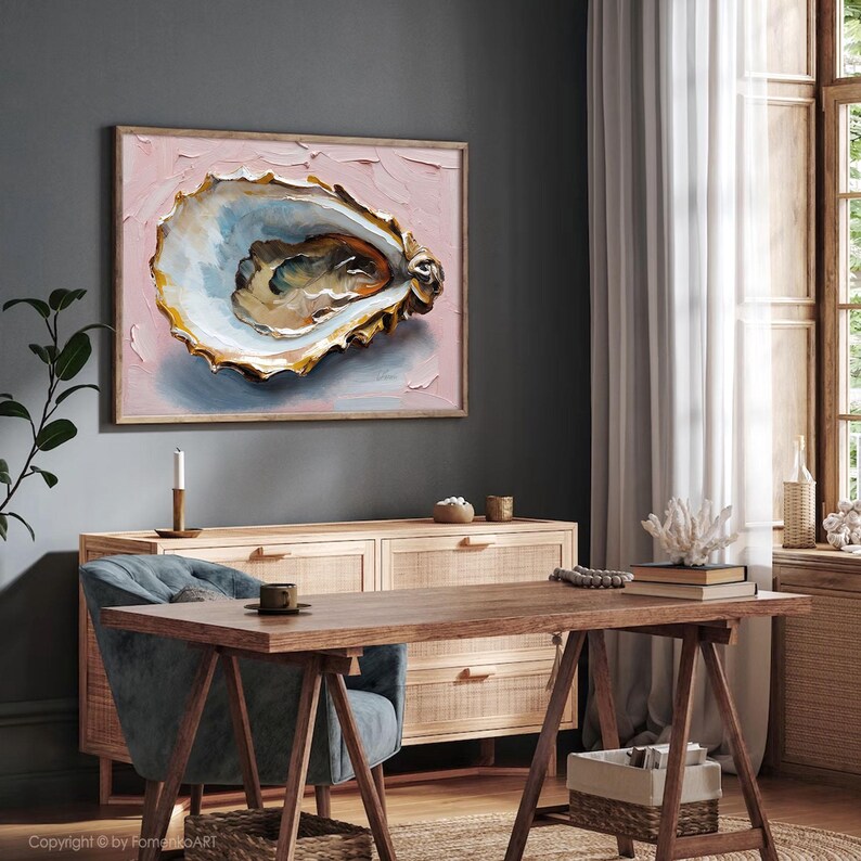 May include: An oyster shell painting with a light pink background and a wooden frame. The oyster shell is detailed with shades of white, gold, and brown. The artwork is displayed in a room with a wooden desk and cabinet.