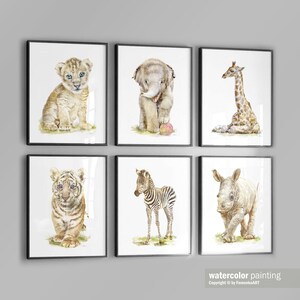 May include: Set of six watercolor paintings featuring baby animals. The paintings include a lion cub, elephant calf, giraffe calf, tiger cub, zebra foal, and rhinoceros calf. Each painting is framed in a black frame.