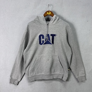 May include: A gray hooded sweatshirt with a front pocket and the word "CAT" in navy blue with a logo. The sweatshirt is hanging on a wooden hanger.