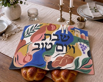May include: A rectangular fabric challah cover featuring a colorful abstract illustration of pomegranates, grapes, a kiddush cup, and two braided loaves of bread. The Hebrew text reads Shabbat Shalom, with the English text The Cohen Family below.