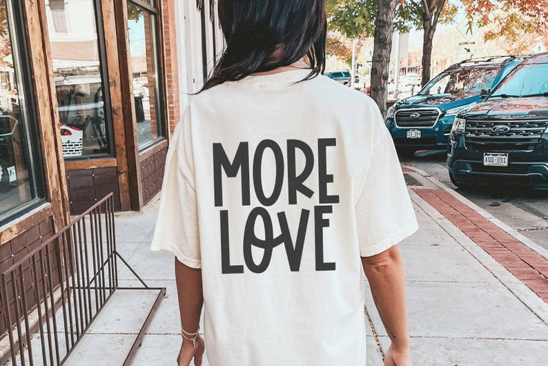 May include: A white t-shirt with the text "MORE LOVE" printed in black on the back.
