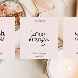 Peut inclure: Trois &eacute;tiquettes roses avec du texte noir sur fond blanc. Les &eacute;tiquettes indiquent "wild skin co" et pr&eacute;sentent diff&eacute;rents parfums : "Peach Sugar", "Lemon Orange" et "Wild Rosey". Chaque &eacute;tiquette comprend &eacute;galement le texte "all natural soap made in tx".
