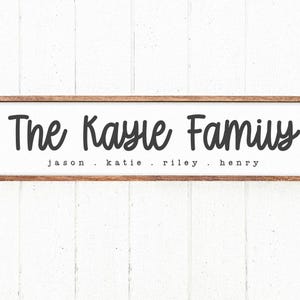 Op de afbeelding: Een houten bord met de tekst "The Kayle Family" in een cursief schrift. Onder de tekst staat "jason. katie. riley. henry."