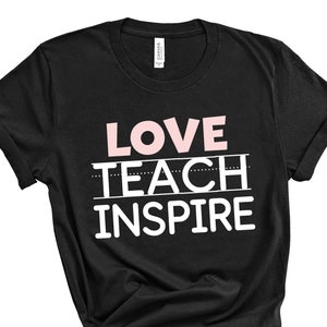 Op de afbeelding: Zwart T-shirt met de tekst "LOVE TEACH INSPIRE" in witte en roze letters.