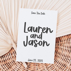May include: Save the date card with a white background and black text. The text reads "Save The Date", "Lauren and Jason", and "June 23, 2023".