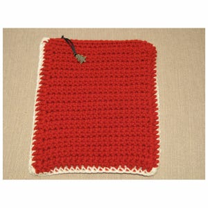 May include: Red crocheted square kitchen potholder with a white crocheted border and a small metal Christmas tree charm.