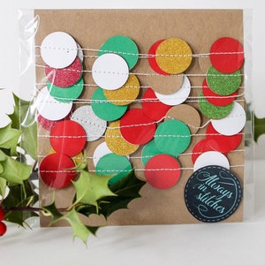 May include: A package of red, green, gold, white, and silver glitter paper circles strung together on white twine. The package is labeled "Always in Stitches".