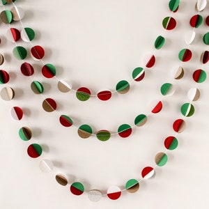 May include: A festive garland made of paper circles in red, green, and brown. The circles are strung together with white thread and are arranged in a repeating pattern.