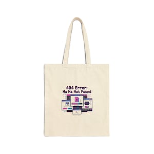 May include: Beige tote bag with a computer error message design. The graphic features multiple computer screen illustrations with the text "404 Error: Ha Ha Not Found" in black and purple. The bag has a simple, rectangular shape with two handles.