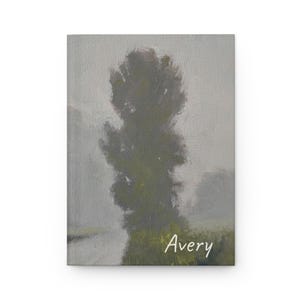 May include: A rectangular journal with a textured cover featuring an oil painting of a tall, dark green tree standing in a misty, grey landscape. The name Avery is printed in white, cursive script in the bottom right corner of the cover.