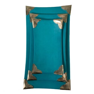 Puede incluir: Tres bandejas rectangulares de color turquesa con esquinas de metal dorado. Las bandejas están apiladas una encima de la otra.