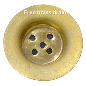 Puede incluir: Un desag&uuml;e de lat&oacute;n dorado con cinco agujeros. El texto "Free brass drain" est&aacute; escrito encima del desag&uuml;e.
