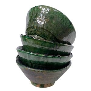 Op de afbeelding: Een stapel van vier groene keramische kommen met een geglazuurde afwerking. De kommen zijn in elkaar genest, met de grootste kom onderaan en de kleinste bovenaan.