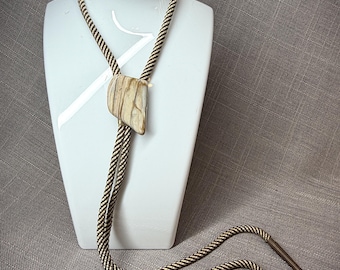 Corbata bolo estilo suroeste, color marfil pulido, con cordón ajustable.