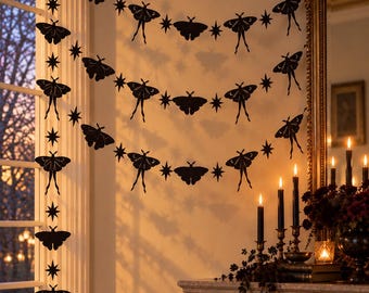 May include: A black paper garland featuring repeating cutouts of moths and four-pointed stars strung together. The decorative banner displays various moth silhouettes with delicate wing details and pointed star shapes, arranged in three horizontal rows.