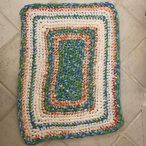 Cotton rag rug hand made with recycled linens. Blue, green, orange, white. 28“ x 21“ are washable, sustainable, durable, reversible.