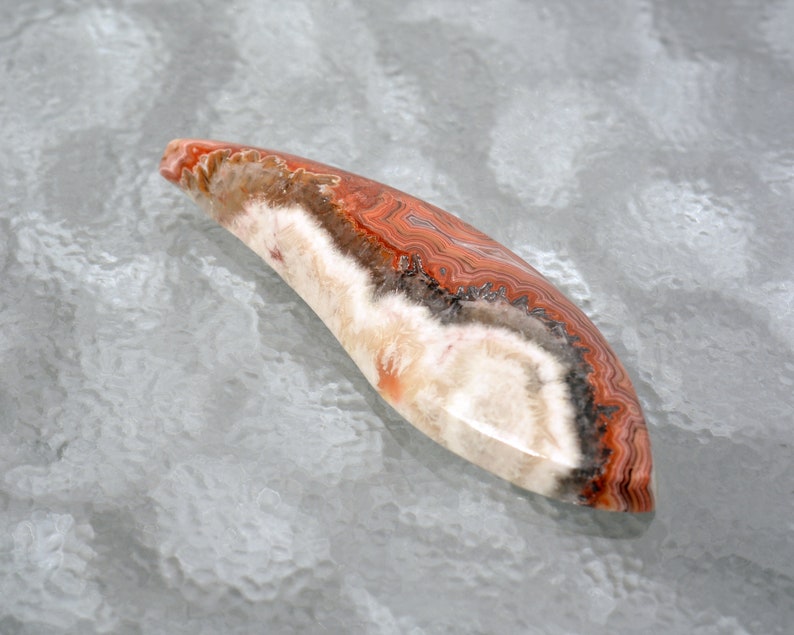 Laguna Agate Hand Cut Free Form Designer Cabochon With Fortification Patterns in Reds Grays and White Colors 51.3 x 16.6 x 6.3mm #4229LAG