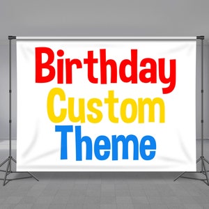 May include: White backdrop with the text "Birthday Custom Theme" in red, yellow, and blue lettering. The backdrop is attached to a black tripod stand.